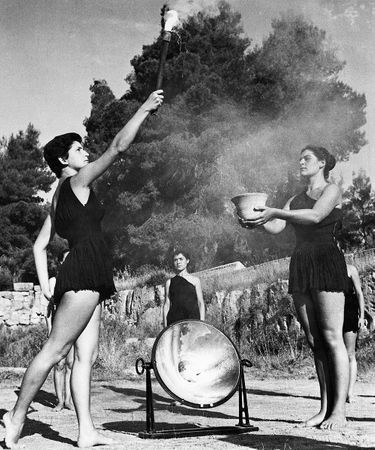 Des jeunes filles grecques, vêtues de costumes grecs anciens appropriés, allument la torche olympique à Olympie, avant les Jeux de Helsinki, en 1952.